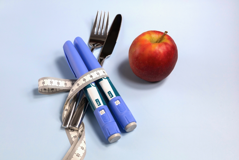 Apple with Mounjaro wrapped in tape measure